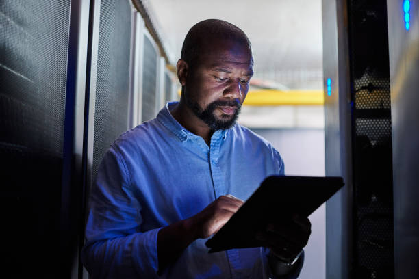 istock Shot of a male engineer using a digital tablet while working in a server room 1333959177