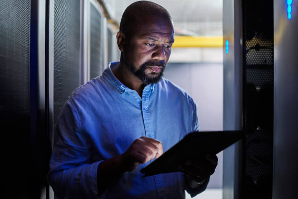 istock Shot of a male engineer using a digital tablet while working in a server room 1333959185