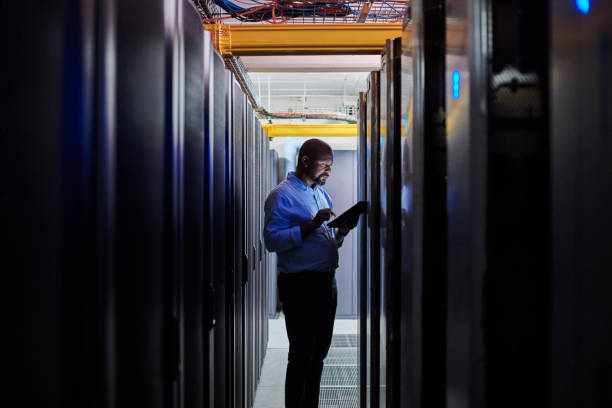 istock Shot of a male engineer using a digital tablet while working in a server room 1333959188
