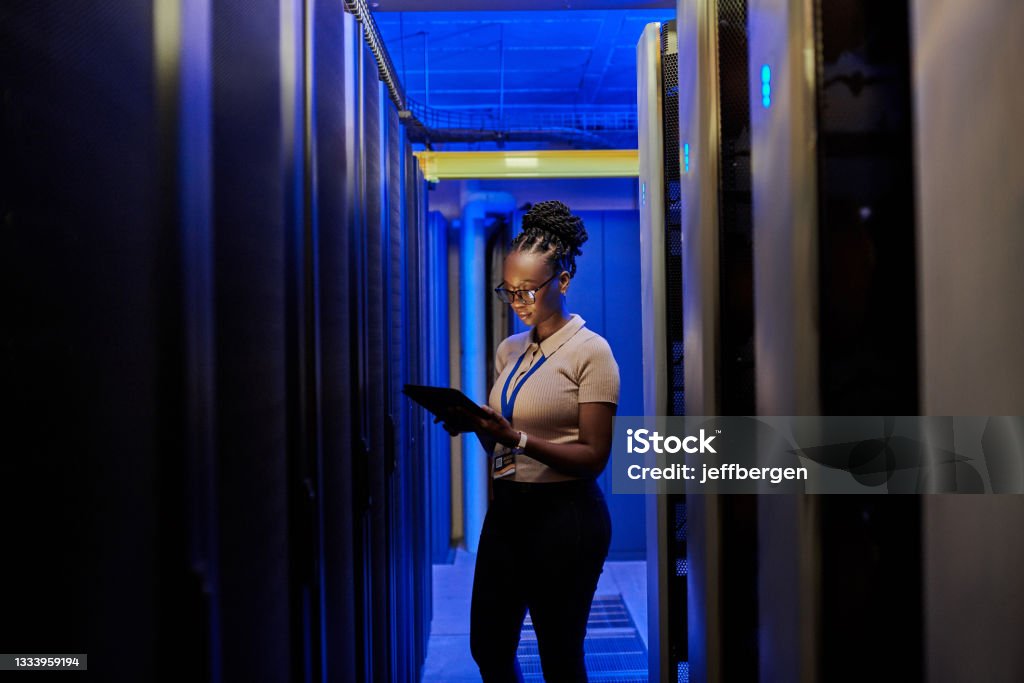 Shot of a young female engineer using a digital tablet while working in a server room I'll make sure that your data servers and network perform optimally Technology Stock Photo