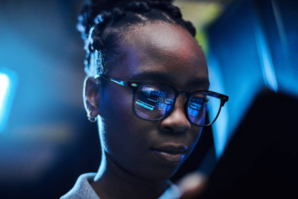 foto de una joven ingeniera usando una tableta digital mientras trabajaba en una sala de servidores - data center computer programmer women fotografías e imágenes de stock