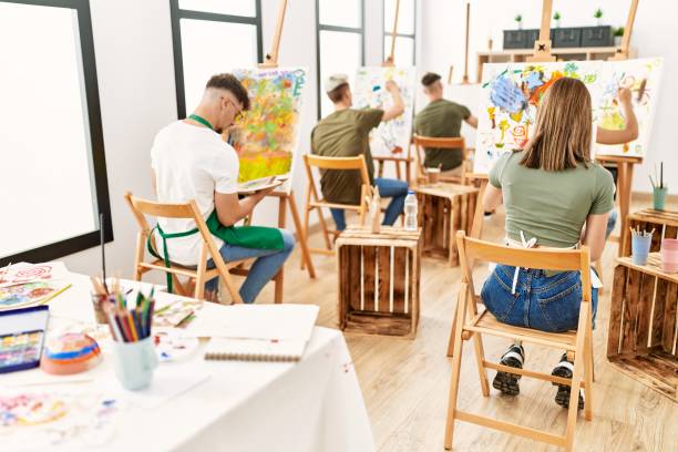 istock Group of people sitting on back view drawing at art studio. 1333960371