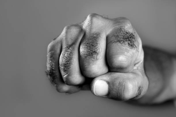 istock Hairy man fist closeup expression over gray 1333961672