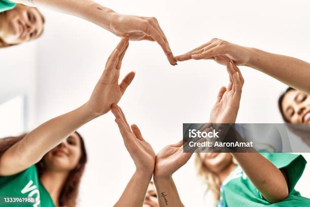 Group Of Young Volunteers Woman Smiling Happy Make Heart Symbol With Hands Together At Charity Center Stock Photo - Download Image Now