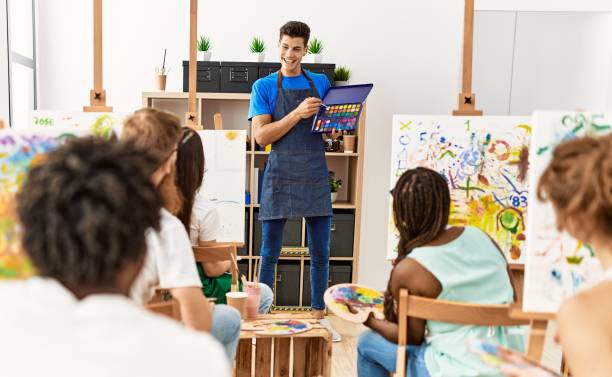 istock Group of people smiling happy drawing in paint class at art studio. 1333965999