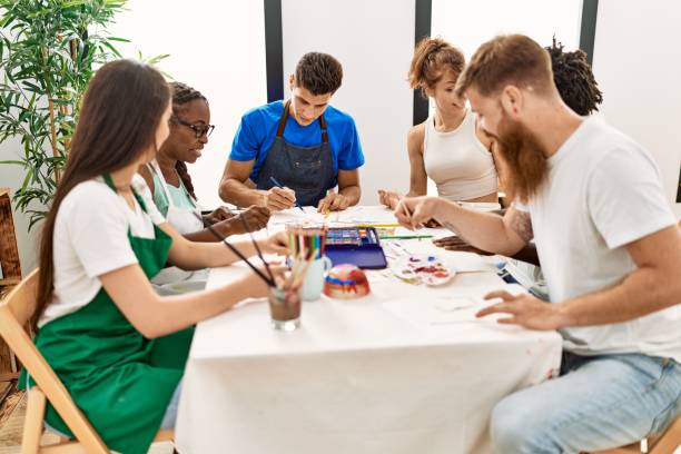 istock Group of people smiling happy drawing sitting on the table at art studio. 1333966021