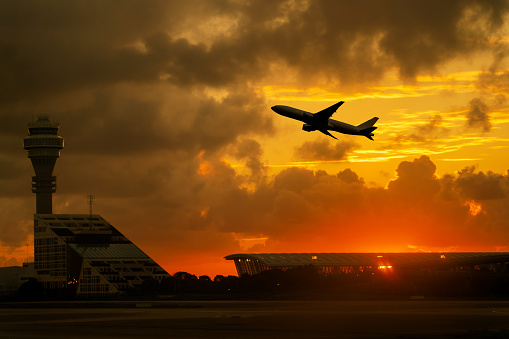 airplane take off from airport with cloudy sky during sunrise.