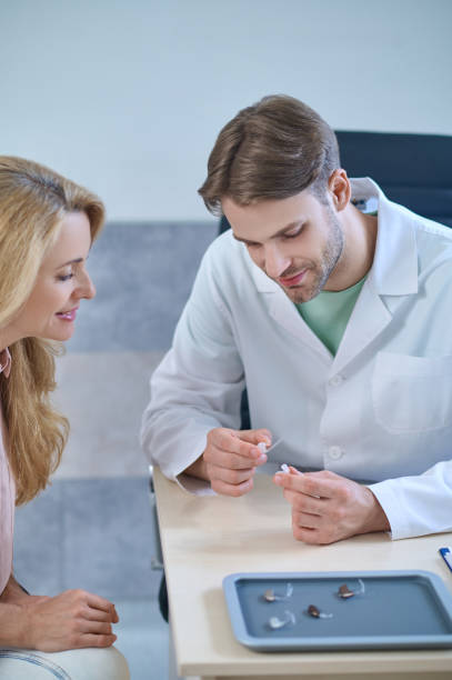 istock Experienced audiologist offering a hearing device to his middle-aged patient 1333968729