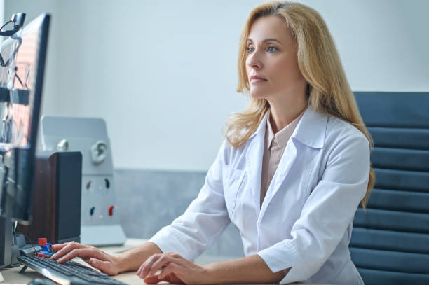 istock Beautiful blonde doctor focused on checking her email 1333968776