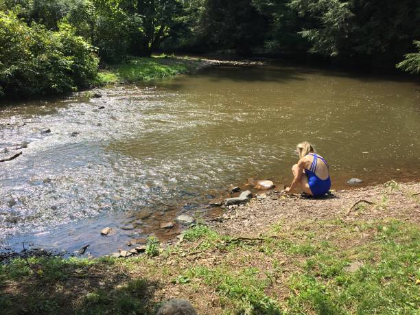 istock WS woman kneels in stream 1333970233