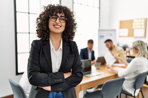 young middle east businesswoman smiling happy standing with arms crossed gesture at the office during business meeting. - businessman business arms crossed business person imagens e fotografias de stock