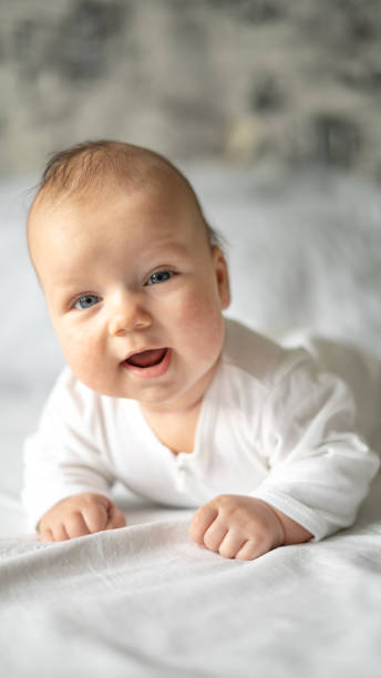 istock Satisfied smiling baby lying on his stomach on a white background. 1333970882