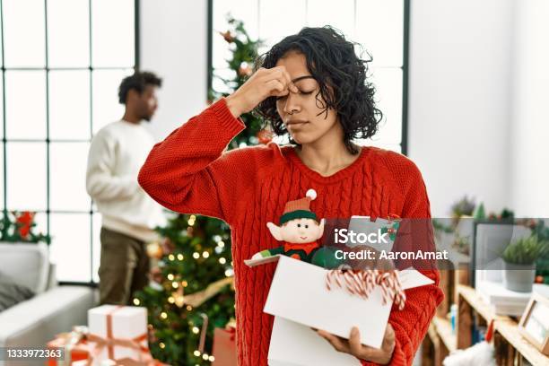 Young Hispanic Woman Standing By Christmas Tree With Decoration Tired Rubbing Nose And Eyes Feeling Fatigue And Headache Stress And Frustration Concept Stock Photo - Download Image Now