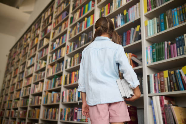 istock Young Caucasian girl with textbooks at the library 1333972855