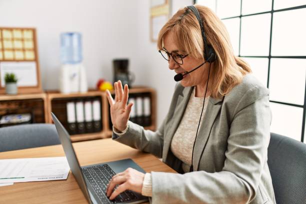 istock Middle age call center agent having video call using laptop at the office. 1333973671