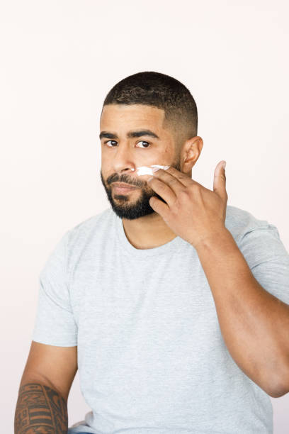 istock Man looking at camera applying skin products 1333973830