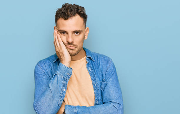 Young hispanic man wearing casual clothes thinking looking tired and bored with depression problems with crossed arms. Young hispanic man wearing casual clothes thinking looking tired and bored with depression problems with crossed arms. 25 year old man portrait stock pictures, royalty-free photos & images