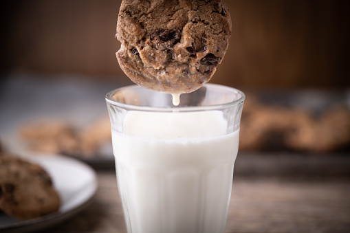 dipping chocolate chip cookie into milk