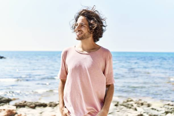 istock Young hispanic man smiling happy standing at the beach. 1333977232