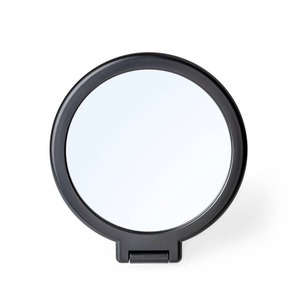 istock Cosmetic mirror isolated on white background. Desktop makeup mirror with stand close-up. Home round vanity mirror in a black plastic frame. Beauty mirror template. 1333981877