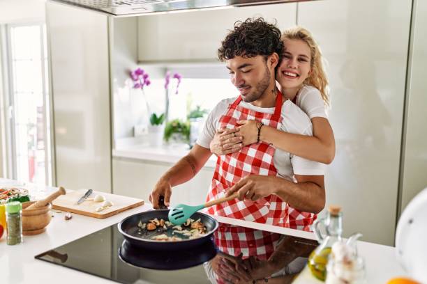 istock Young couple smiling happy and hugging cooking at kitchen. 1333982012