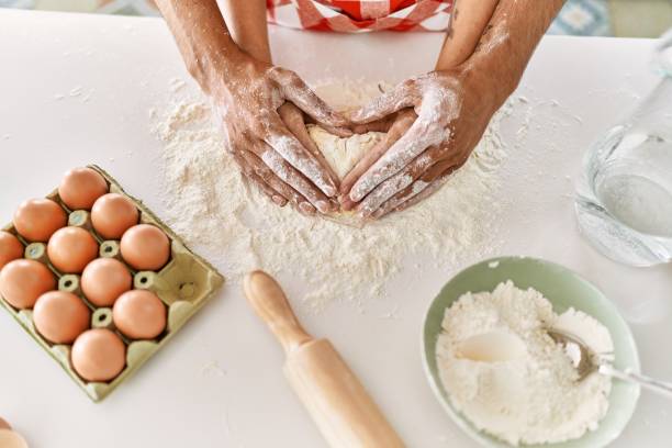 istock Hands of couple kneading dough at kitchen. 1333982066