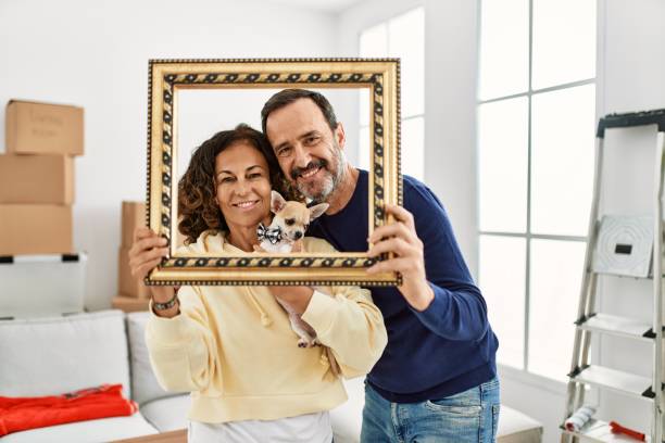 istock Middle age hispanic family smiling happy holding empty frame at new home. 1333984411
