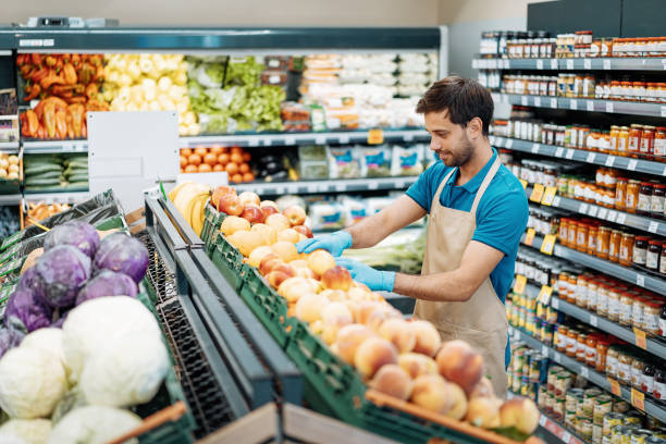 istock Employee in supermarket arranging fresh fruit 1333985194