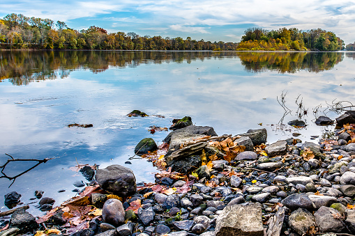 The cloudy and blue sky is reflected in the calm waters of the Delaware River, in Bucks County, Pennsylvania
