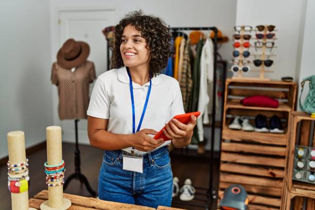 young latin shopkeeper woman using touchpad working at clothing store. - boutique owner store retail occupation imagens e fotografias de stock