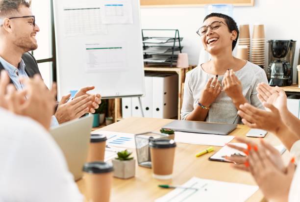 istock Group of business workers smiling and clapping to partner at the office. 1333988892