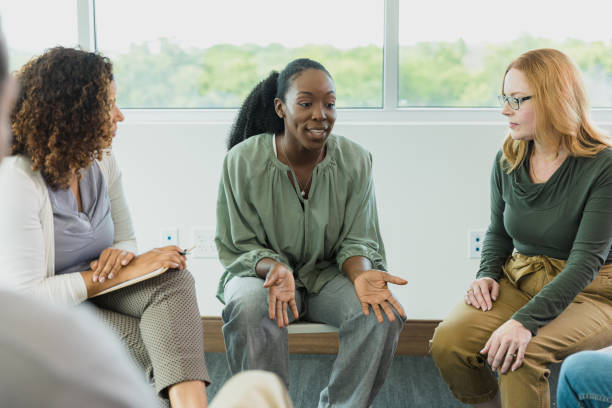 istock Woman gestures and shares during group therapy 1333989499