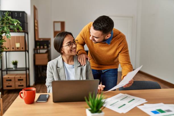 istock Two business workers smiling happy working sitting on desk at the office. 1333989760