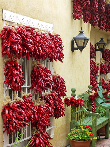 Alley way with hanging chili peppers and park bench in old town Albuquerque, New Mexico.