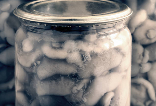 Home preservation of products: glass jars with pickled mushrooms with spices closed