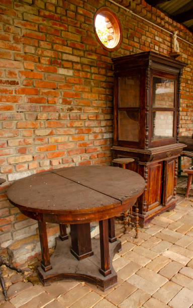 Antique brown table and cupboard on brick wall background. Objects of old interior design. side view