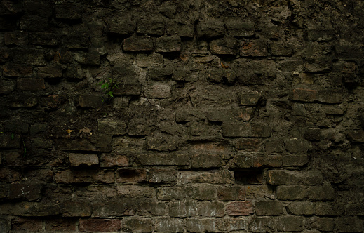 Fondo de mampostería de ciudad en ruinas envejecida. Vintage frente a la yarda de la fortaleza del castillo. Sucia fachada de roca rural fortificada textura de pared, húmeda planta baja espeluznante. photo