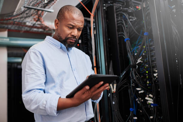 istock Shot of a mature man using a digital tablet in a server room 1334003866