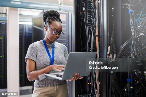 Shot Of A Young Woman Using A Laptop In A Server Room Stock Photo - Download Image Now