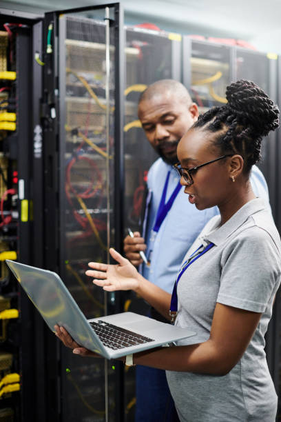 istock Shot of two technicians working together on a laptop in a server room 1334004294