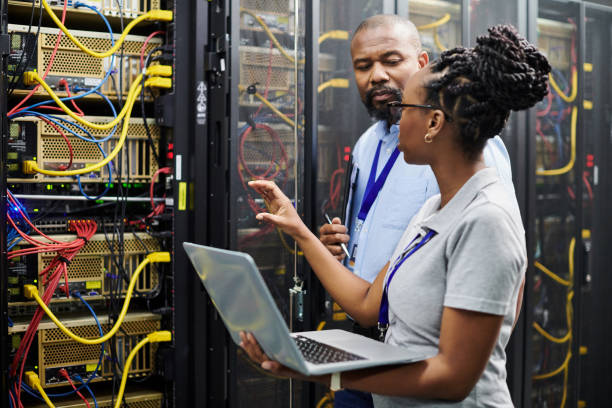 istock Shot of two technicians working together in a server room 1334004313
