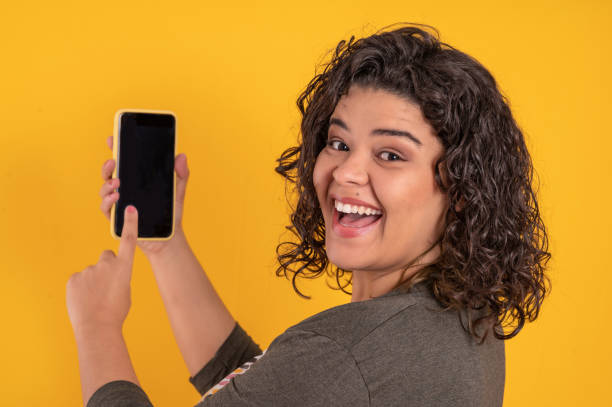 istock young woman with a cell phone on colorful background 1334005373