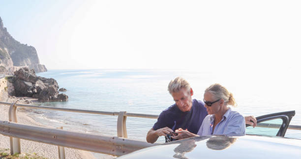 istock Mature couple relax outside car, on coastal road 1334011237
