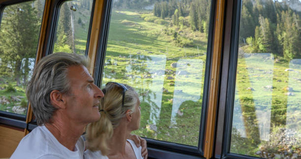istock Mature couple relax in train, riding up mountain 1334011333