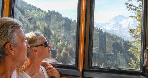 istock Mature couple relax in train, riding up mountain 1334011346