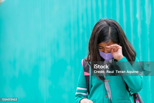 Mexican Girl Wearing Uniform And Face Mask Crying On The Back To School Stock Photo - Download Image Now