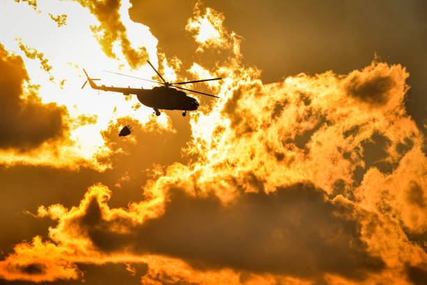 Helicopter is fighting a wildfires Dramatic footage of a helicopter flying into a burning flames climate justice photos stock pictures, royalty-free photos & images