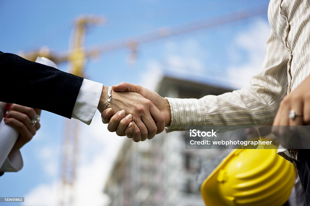 Selective focus of handshake in construction yard Construction deal, selective focus, canon 1Ds mark III Trust Stock Photo