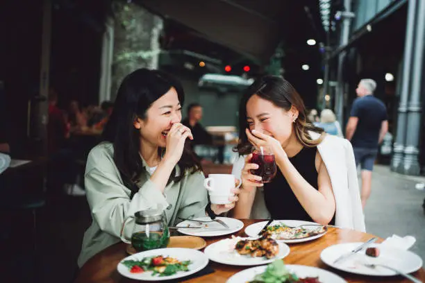 Asian men and women happy chatting over lunch gathering.