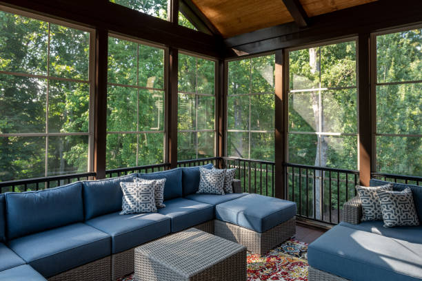 New Porch and Patio Furniture on a Sunny Day New modern screened porch with patio furniture, summertime woods in the background. porch stock pictures, royalty-free photos & images